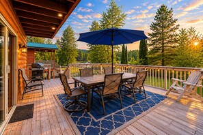 A wooden deck with a table and chairs, a grill, and an umbrella. - Riverwood Lodge 5 Bedroom Home by NW Comfy Cabins by RedAwning (Leavenworth)