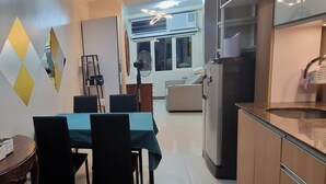 A compact living space with a dining area, kitchenette, and a view of the living room.