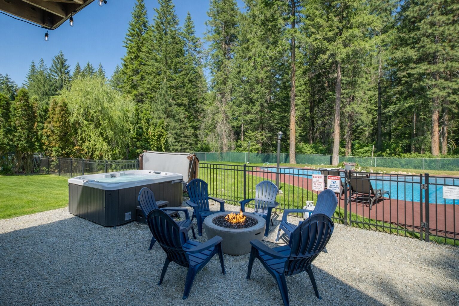 Patio esterno con vasca idromassaggio, braciere e poltrone Adirondack.