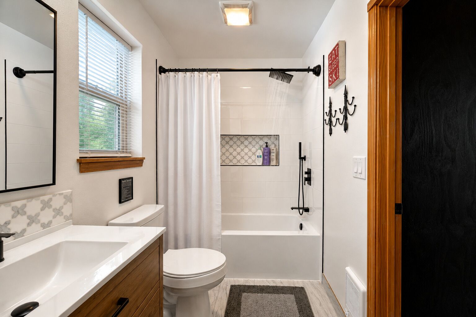 Een moderne badkamer met douche, toilet en wastafel.