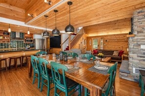 A spacious wooden interior with a dining area, kitchen, and living space.