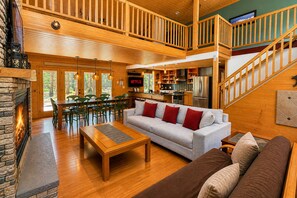 A spacious living area with a fireplace, a dining table, and a sofa.