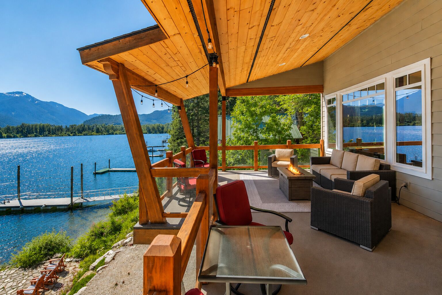 A covered outdoor seating area with a view of a lake and mountains.