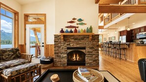 Un salon chaleureux avec une cheminée en pierre, des meubles en bois et une vue sur un lac.