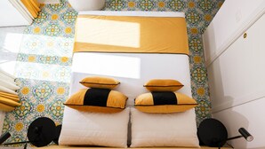 A compact bedroom with a bed, a desk, and a small chair. - Relais Metis (Naples)