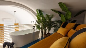 A modern bathroom with a freestanding bathtub, a shower, and a large window with blinds. - Relais Metis (Naples)