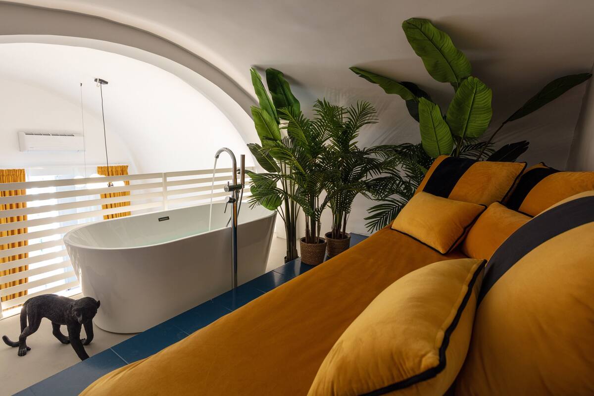 Une salle de bain moderne avec une baignoire sur pieds, une douche et une grande fenêtre équipée de stores.
