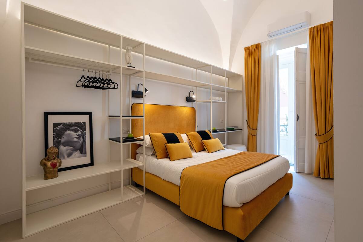 Une chambre moderne avec un lit, des étagères intégrées et une vue sur l’extérieur.