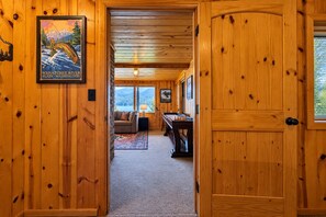 A wooden interior with a couch, a pool table, and a framed picture on the wall. - All About The Lake 4 Bedroom Home by NW Comfy Cabins by RedAwning (Leavenworth)
