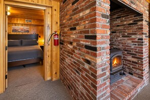 Ein gemütliches Zimmer mit einem Bett, einem Kamin und einem Feuerlöscher.