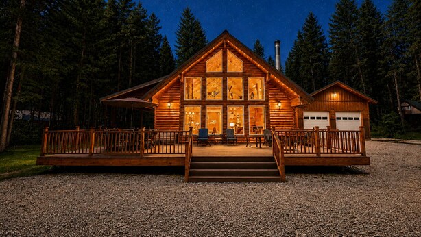 A log cabin with a porch, a garage, and a starry night sky. - Getaway Moose 3 Bedroom Home by NW Comfy Cabins by RedAwning (Leavenworth)