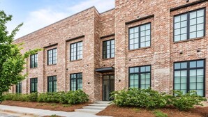 A multi-story brick building with large windows and a central entrance.