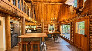 Ein Interieur einer Blockhütte mit Küche, Essbereich und einem Schild mit der Aufschrift 'CABINS'.