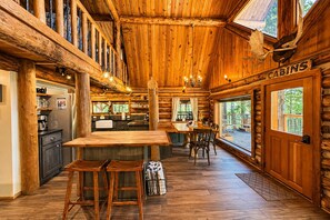 A log cabin interior with a kitchen, dining area, and a sign indicating 'CABINS'. - Guten Cabin 3 Bedroom Home by NW Comfy Cabins by RedAwning (Leavenworth)