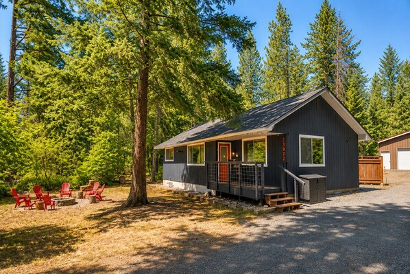 A cabin with a porch, a deck, and a garage. - Rhodie House 3 Bedroom Home by NW Comfy Cabins by RedAwning (Leavenworth)