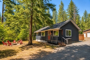 A cabin with a porch, a deck, and a garage.