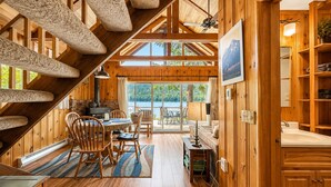 Un intérieur en bois comprenant un coin repas, une cuisine et une vue sur un lac.