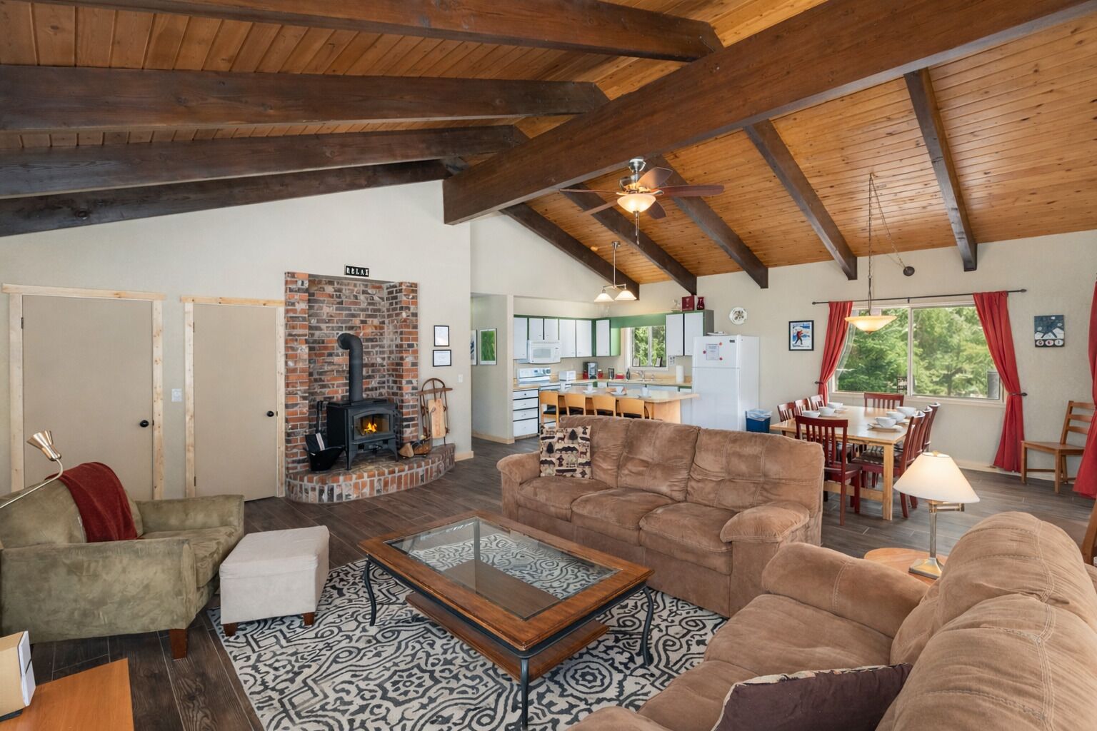 A spacious living room with a fireplace, a dining area, and a kitchen.