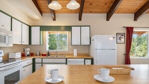 A kitchen with wooden cabinets, a white refrigerator, a microwave, a toaster, and a coffee maker.