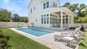 A modern house with a large pool, a covered patio with lounge chairs, and a well-maintained lawn. - Blue Mountain Beach | Pool | Bikes (Santa Rosa Beach)