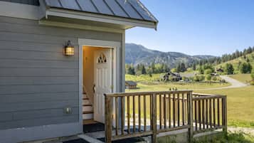 A house with a wooden deck and a door leading to a staircase.