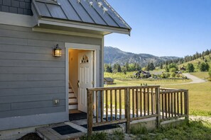 A house with a wooden deck and a door leading to a staircase. - Berg Haus 1 Bedroom Home by NW Comfy Cabins by RedAwning (Leavenworth)