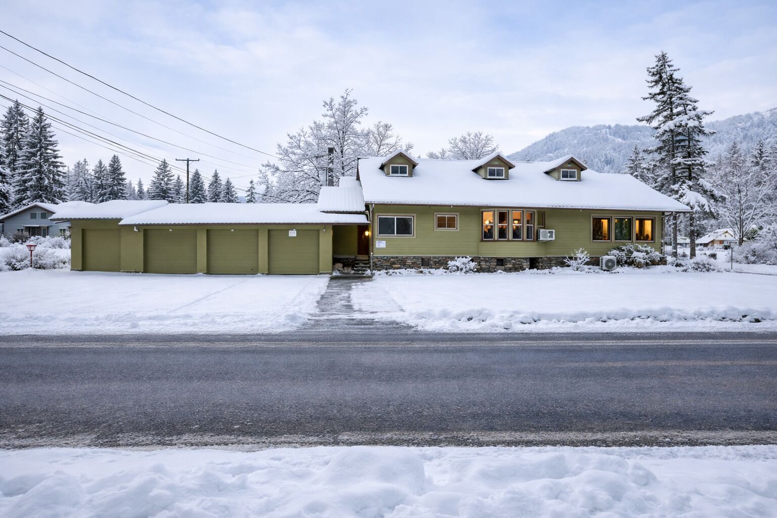 A two-story house with a garage, a covered driveway, and a snow-covered landscape.