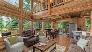 A spacious wooden cabin with a balcony, a dining area, and a kitchen. - Bearfoot Chalet 3 Bedroom Home by NW Comfy Cabins (Leavenworth)