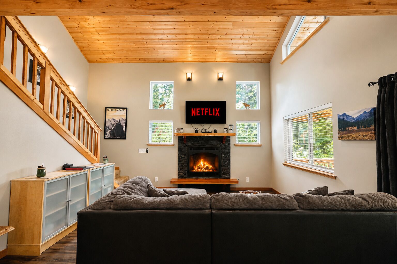 A living room with a fireplace, a sofa, a TV, and a staircase.