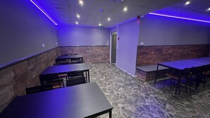 L’intérieur d’un restaurant, avec un sol en pierre, des tables et des chaises.