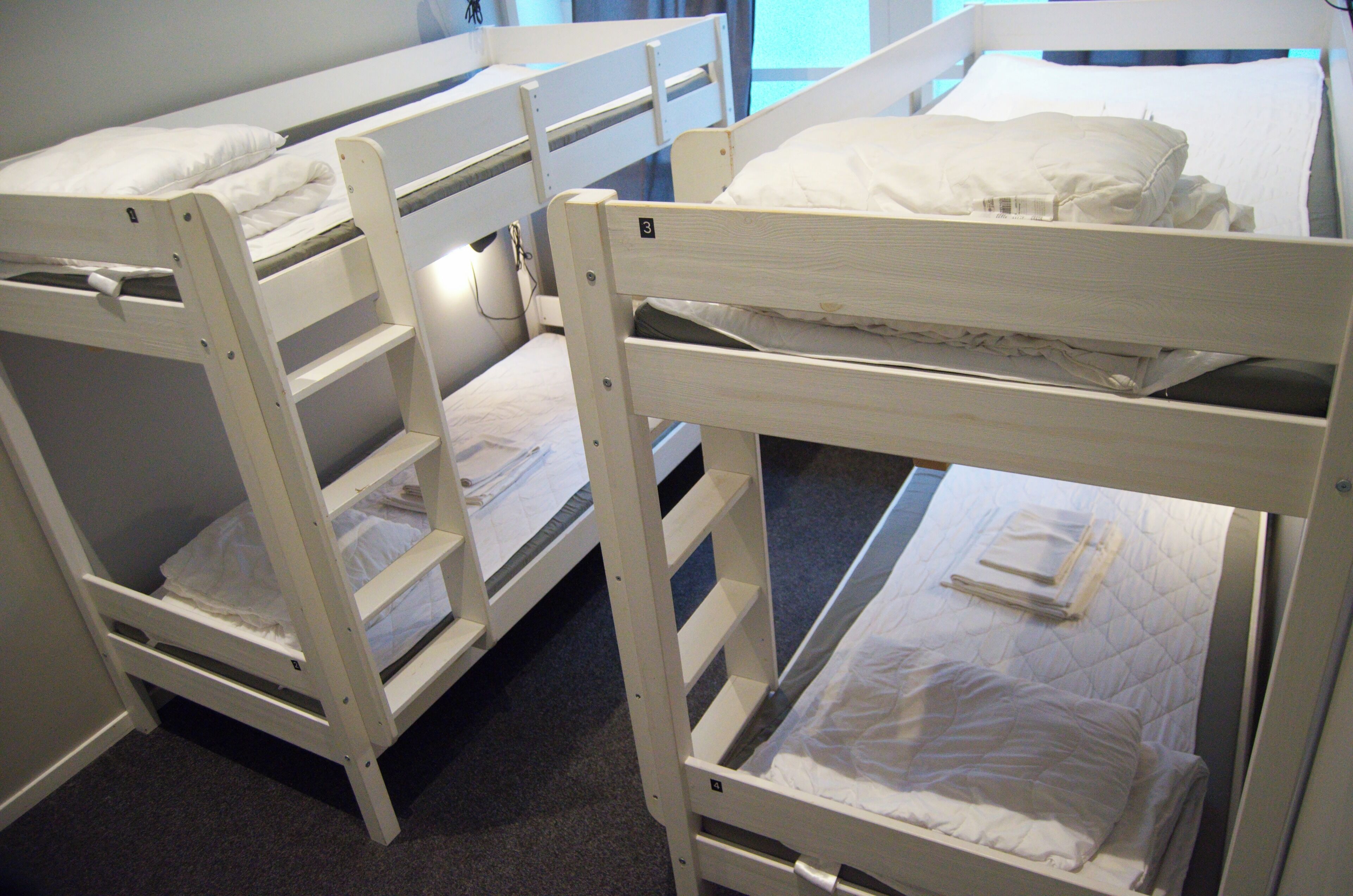 Three bunk beds in a room with a carpeted floor.