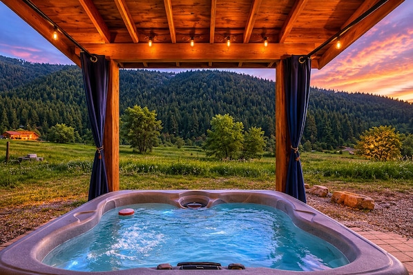 A hot tub with a view of a forested mountain range.
