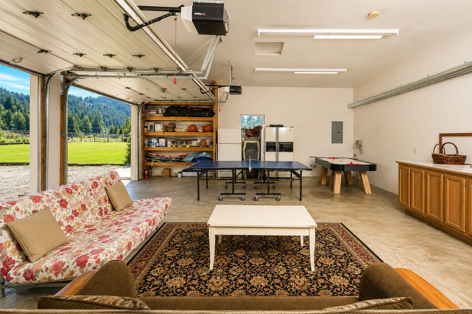 A spacious living area with a sofa, a coffee table, a ping pong table, and a pool table.