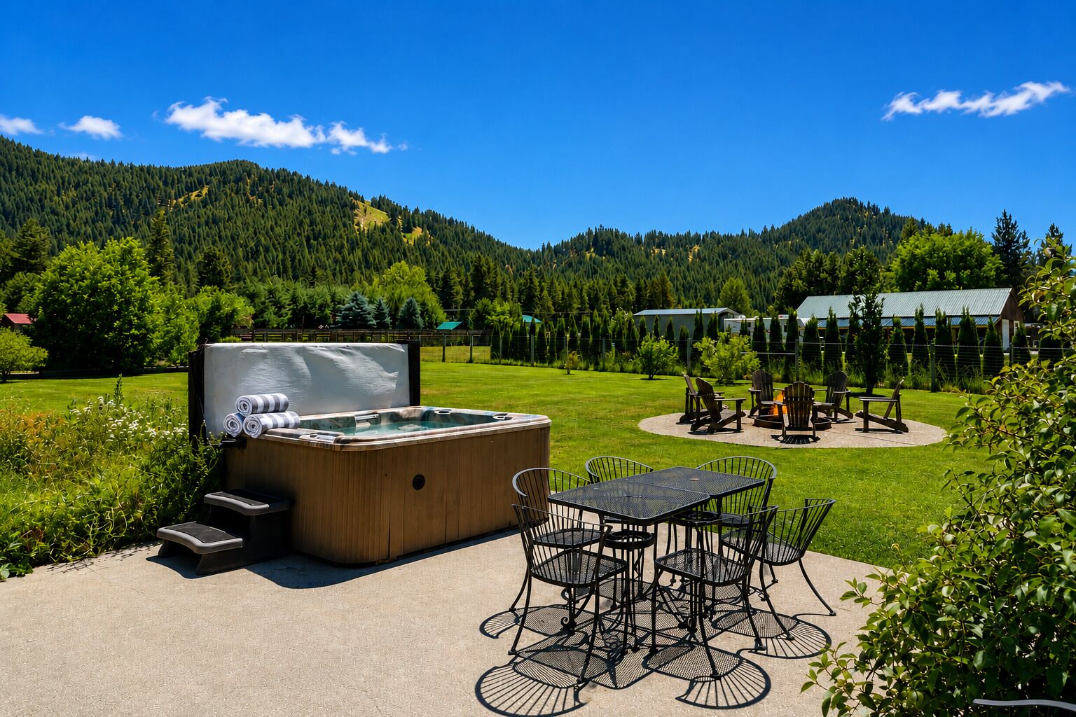 Un bain à remous, un espace salon extérieur et une vue sur une montagne boisée.
