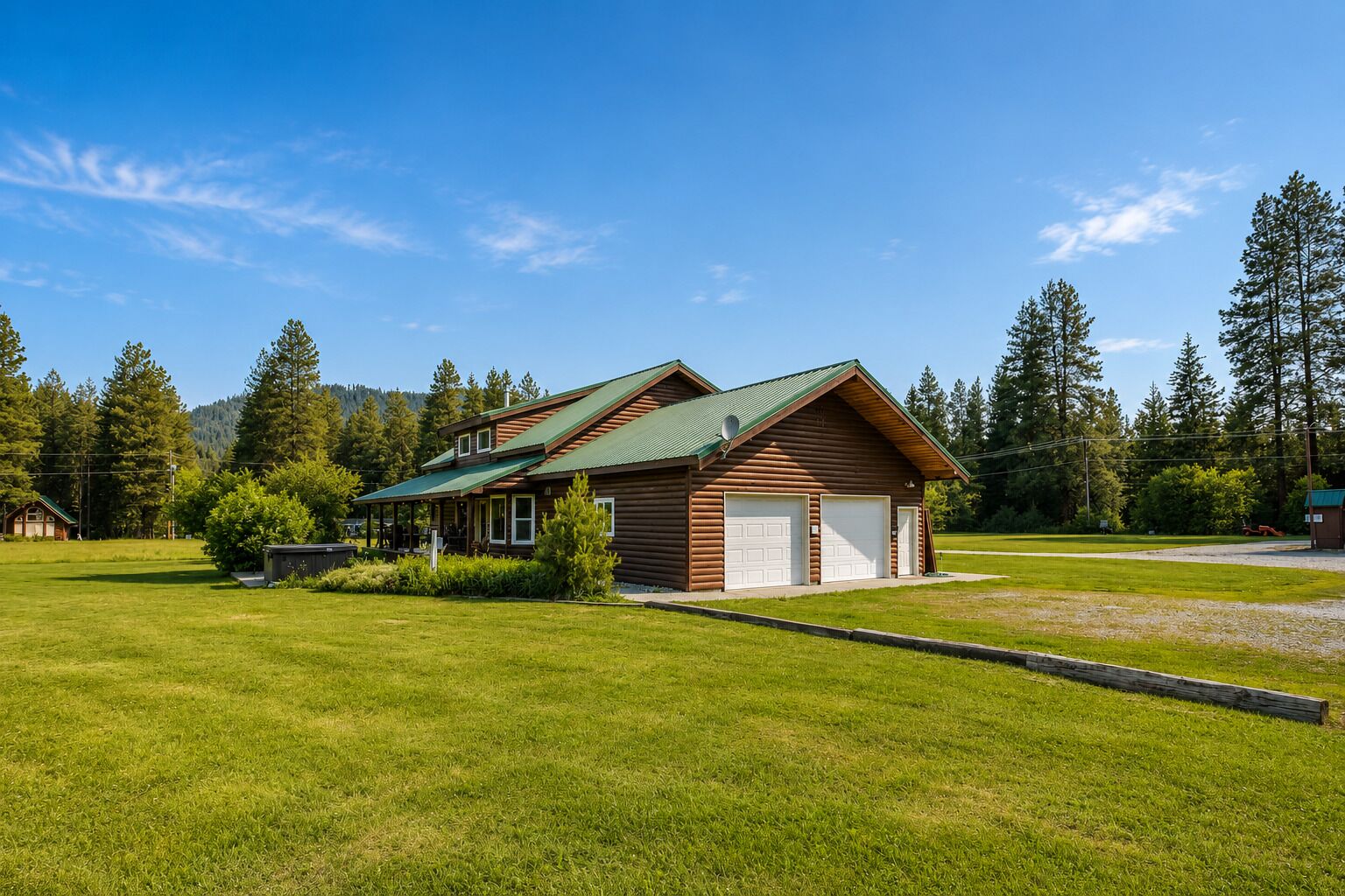A log cabin with a green roof, a covered porch, and a garage.