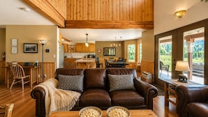 A cozy living room with a leather sofa, wooden dining table, and a bowl of popcorn.