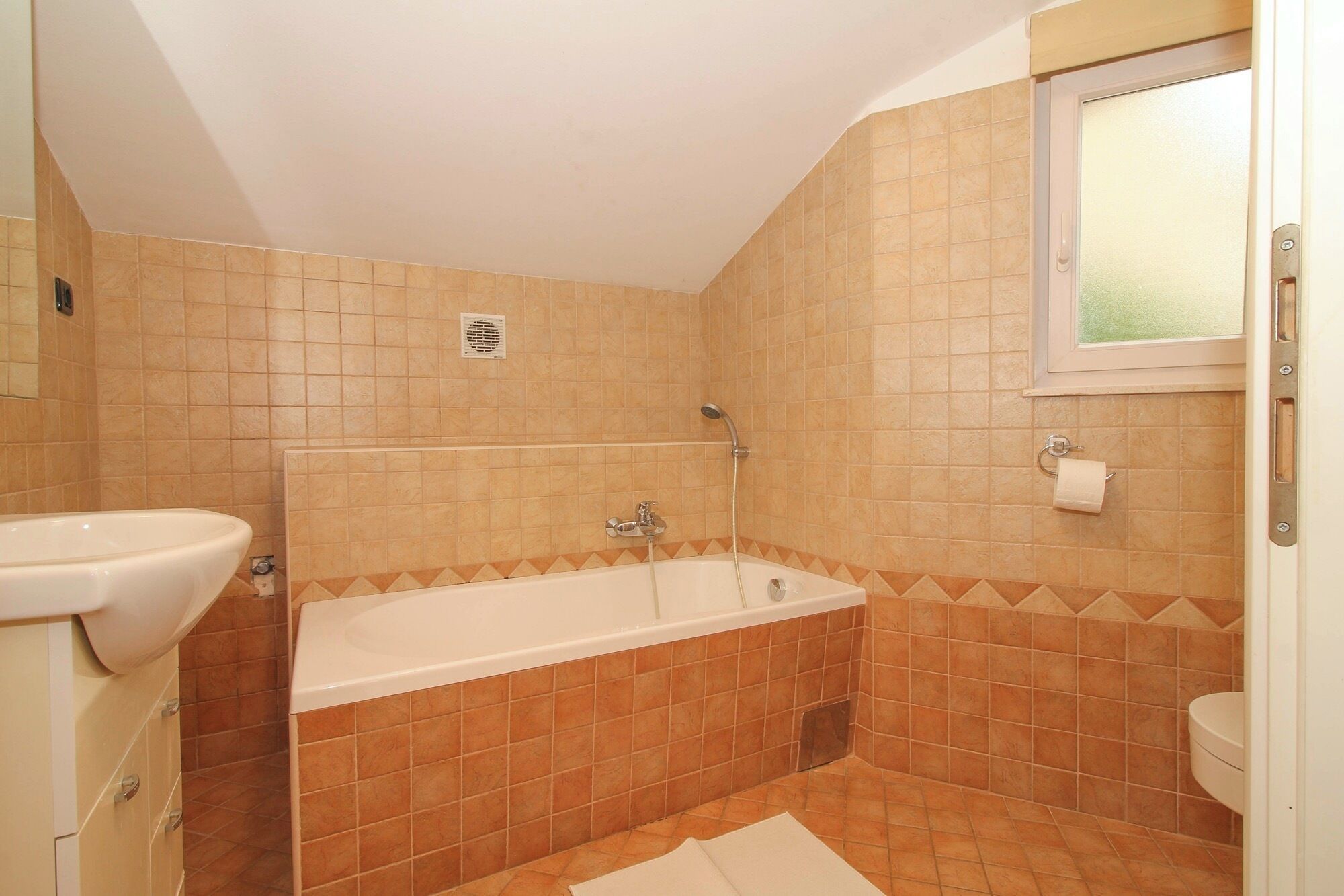 Ein Badezimmer mit einer Badewanne, einer Toilette und einem Waschbecken.
