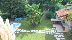 A well-maintained garden with a swimming pool, stone pathway, and a small palm tree. - Bruk in Lovran - Kvarner Region / Bruk in Lovran - Appartement für 2 Personen AP2 (Lovran)