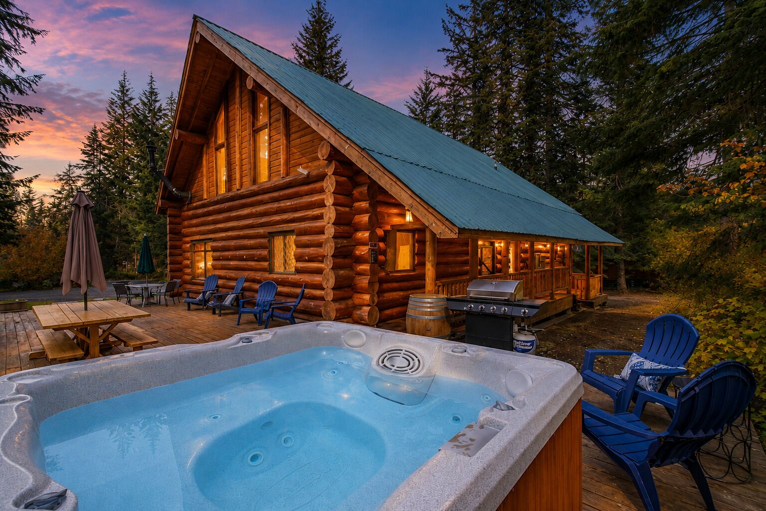 A log cabin with a hot tub, outdoor seating, and a barbecue area.