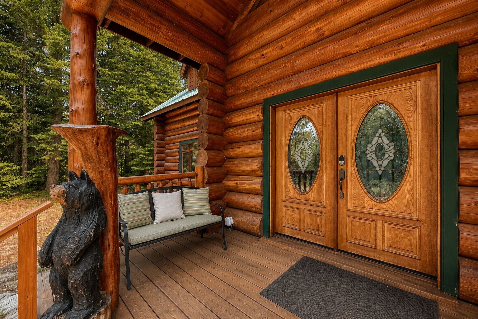 A log cabin with a wooden porch, a bench, and a double door with glass panels.