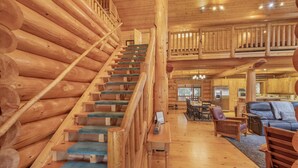 A wooden staircase with blue carpet leading to a second-floor balcony. - Soaring Pines Lodge 1 Bedroom Home by NW Comfy Cabins by RedAwning (Leavenworth)