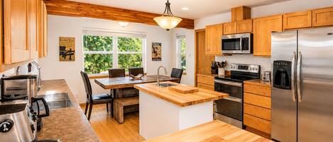 Une cuisine moderne avec des meubles en bois, des appareils électroménagers en acier inoxydable et un îlot central.