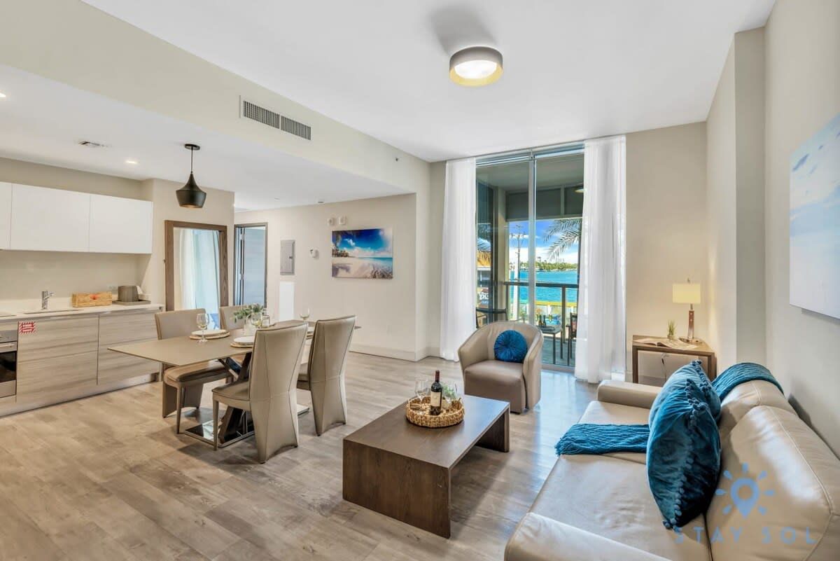 Uma sala de estar moderna com sofá, mesa de centro e área de jantar.