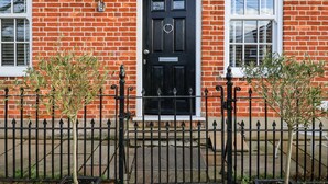 A red brick building with a black door, two windows, and a sign above the door. - Ebenezer Chapel (Saxmundham)