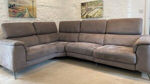 A sectional sofa in a room with white textured walls and two paintings. - Historic remodelled stable barn near nature conservation (Pulborough)