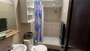 Une petite salle de bain comprenant un lavabo, des toilettes et un espace douche.