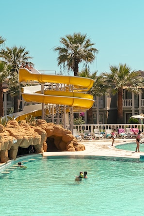A pool area with a water slide, palm trees, and lounge chairs. - Lucas Didim Resort (Didim)