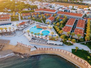 An aerial view of a resort with a large pool, palm trees, and beachfront access. - Lucas Didim Resort (Didim)