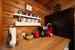 A kitchen counter with a coffee maker, tea kettle, and coffee pods. - A Peace Of Pine 2 Bedroom Home by NW Comfy Cabins by RedAwning (Leavenworth)