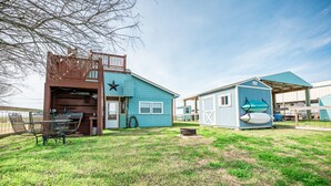 Une maison à deux étages avec un garage et un petit abri de jardin.